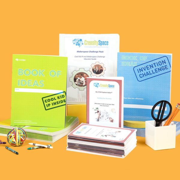 A picture of the contents of the Makerspace Challenge pack - a class set of the Book of Ideas, a class set of student notebooks, a class set of business development notebooks and a lesson guide.